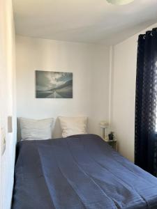 um quarto com uma cama com um cobertor azul em Los Urrutias, Murcia, Mar Menor em Los Urrutias