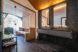 a bathroom with a large sink and a mirror at Black Summit Boutique Resort Laax in Laax