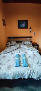 a bed with blue flip flops on top of it at Стаи за гости ОРЕХА Троян Private rooms Oreha in Troyan