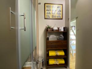 a bathroom with a shower and a dresser with yellow towels at Monolocale Morimondo 1 in Milan +18 photos