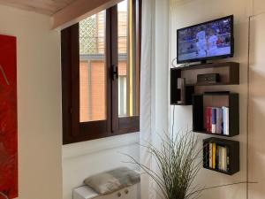sala de estar con ventana y TV en Monolocale Morimondo 1, en Milán