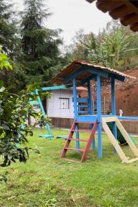 a playground with a blue play structure in a yard at Chácara em Marechal Floriano in Marechal Floriano