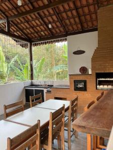 eine Küche mit einem Tisch, einem Tisch und Stühlen in der Unterkunft Chácara em Marechal Floriano in Marechal Floriano