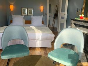 a hotel room with a bed and two chairs at Domaine de Macque, BETZ, 25 mns Roissy CDG in Betz