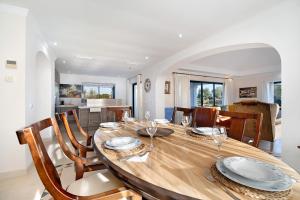 Arcos golf Jacaranda 5 dormitorios في أركوس ديلا فرونتيرا: غرفة طعام مع طاولة وكراسي خشبية