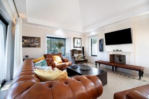 Arcos golf Jacaranda 5 dormitorios في أركوس ديلا فرونتيرا: غرفة معيشة مع أريكة جلدية وتلفزيون
