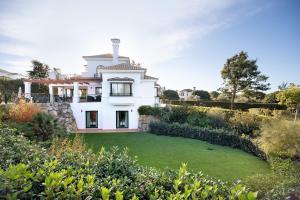 阿爾科斯－德拉弗龍特拉的住宿－Arcos golf Jacaranda 5 dormitorios，一座带绿色草坪的大型白色房屋