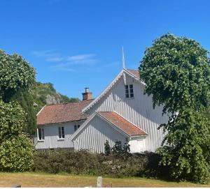 een wit huis met een rood dak bij Sommerdrøm i sør in Mandal