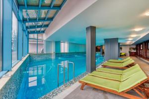 a swimming pool with a row of lounge chairs next to it at MPM Hotel Sport Ski-in, Ski-out in Bansko