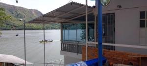 a house on a river with a boat in the water at Apartamento de verano a orillas de la Represa de Prado 1 de 2 in Boquerón de Tena