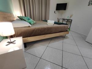 a bedroom with a bed and a lamp on a tiled floor at Nalusa Home in Sarno