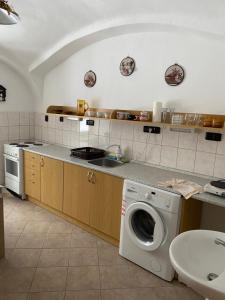 a kitchen with a washing machine and a sink at Penzion Tereza in Horní Vltavice
