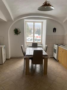 une cuisine avec une table et des chaises ainsi qu'une fenêtre dans l'établissement Penzion Tereza, à Horní Vltavice