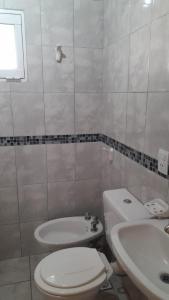 Baño blanco con aseo y lavamanos en Casa Passiflora II en Villa Elisa