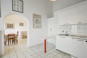uma cozinha com armários brancos e uma mesa em Agriturismo Campo al Crognolo em Sassofortino