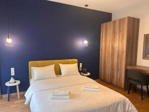 een slaapkamer met een groot bed en 2 handdoeken bij Luxury Suites Athens 2 in Athene