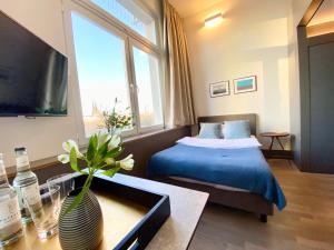 ein Schlafzimmer mit einem Bett und einer Vase auf einem Tisch in der Unterkunft OBERDECK Studio Apartments - Adults only in Hamburg