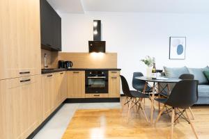 a kitchen and dining room with a table and chairs at Slow River Apartment in Nowe Miasto Lubawskie +20 photos
