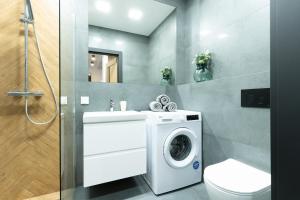 a bathroom with a washing machine and a sink at Slow River Apartment in Nowe Miasto Lubawskie