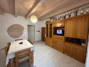 uma sala de jantar com uma mesa e uma televisão em Affittacamere Il Cortile em Chiaravalle