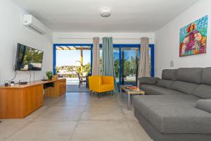 a living room with a couch and a tv at Villa Cangrejita Private Pool Playa Blanca By PVL in Playa Blanca