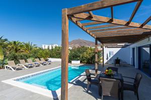 a villa with a swimming pool with a table and chairs at Villa Cangrejita Private Pool Playa Blanca By PVL in Playa Blanca