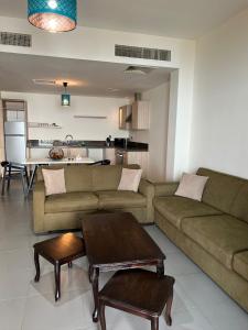 un soggiorno con divano e tavolo e una cucina di E03 Samarah Resort Apartments a Sowayma