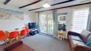 a living room with a couch and a table and chairs at 12 Tudor Court, Tolroy Manor in Hayle