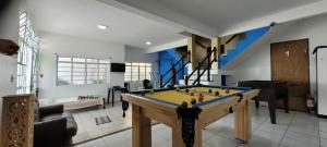 a room with a pool table and a staircase at Recanto Azul in Aparecida