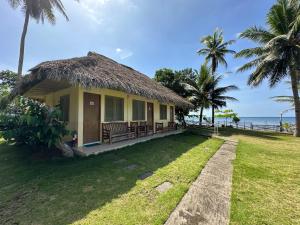 een huis op het strand met een grasdak bij Dancalan Beach Resort in Donsol