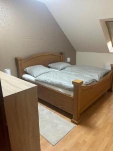 a bedroom with a wooden bed with two pillows at Apartmán 301 VOLT in Nové Zámky