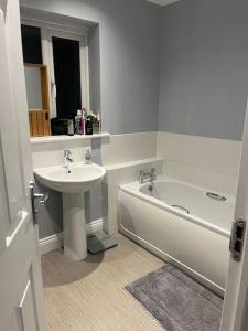 a bathroom with a sink and a bath tub and a sink at Aycliffe Home Away From Home A1 in Newton Aycliffe
