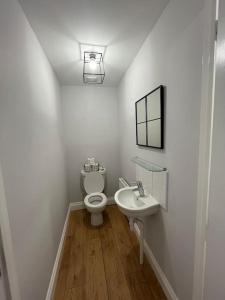 een witte badkamer met een toilet en een wastafel bij Aycliffe Home Away From Home A1 in Newton Aycliffe