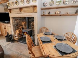 a dining room with a wooden table and a fireplace at Swinhope View in Hexham