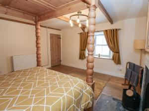 a bedroom with a bed with a wooden post at Swinhope View in Hexham