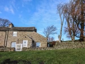 an old stone house with a stone wall at Swinhope View in Hexham