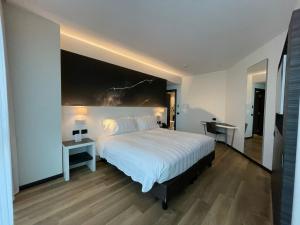 una camera con un grande letto e due tavoli e due lampade di Life Hotel a Bergamo