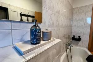 a bottle of alcohol sitting on a shelf in a bathroom at Geräumiges Apartment mit Blick ins Grüne in Groitzsch