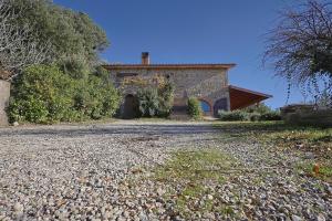 una antigua casa de piedra con una entrada de grava en Agriturismo Campo al Crognolo en Sassofortino