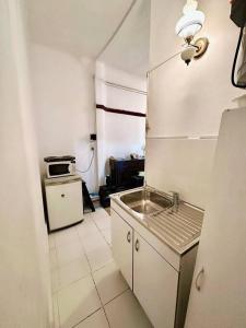 a small kitchen with a sink and a refrigerator at Penthouse en Buenos Aires in Buenos Aires
