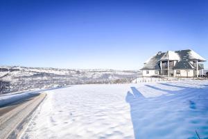 a house sitting on top of a snow covered road at Apartament Magiczny Widok z widokiem na góry in Poronin