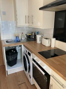 a kitchen with a sink and a washer and dryer at Dream private ensuite apartment in Solihull close to Birmingham airport-city centre and NEC in Birmingham