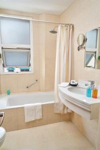 Hotel Cityzen Guayaquil في غواياكيل: حمام مع حوض ومرحاض ومغسلة