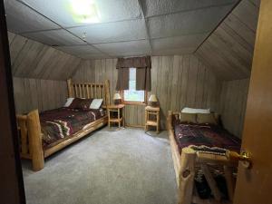 舊福奇的住宿－Camp North Country - Old Forge，一间卧室设有两张床,其中设有窗户。