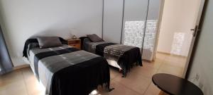 a room with three beds with black blankets on them at Espacio C Montevideo con estacionamiento in Córdoba