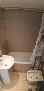 a bathroom with a sink and a tub and a toilet at Espacio C Montevideo con estacionamiento in Córdoba +10 photos