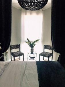 um quarto com 2 cadeiras, uma cama e uma janela em Stylish cocoon in the heart of Le Marais Niçois em Nice