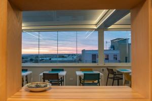 a room with tables and chairs and a large window at Guest House Azzurra in Lampedusa
