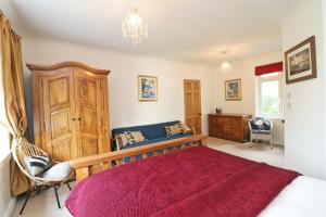 a bedroom with a large bed and a chandelier at Beautiful character cottage in Saint Mawgan