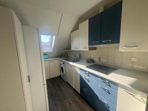 a kitchen with blue and white cabinets and a washer at La Perla del Pirineo in Jaca